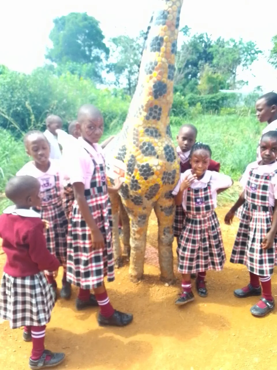 Wisdom Valley pupils gathered around a giraffe sculpture during a school learning activity